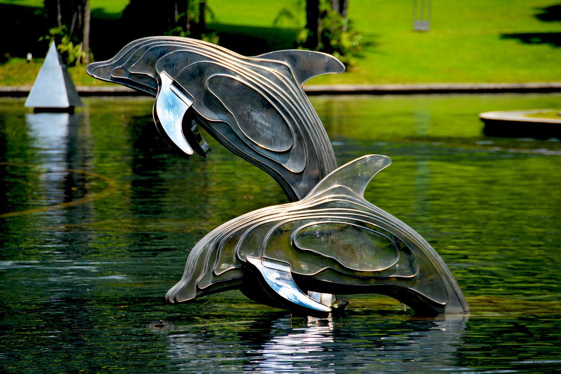 gray and brass metal dolphin pool decor